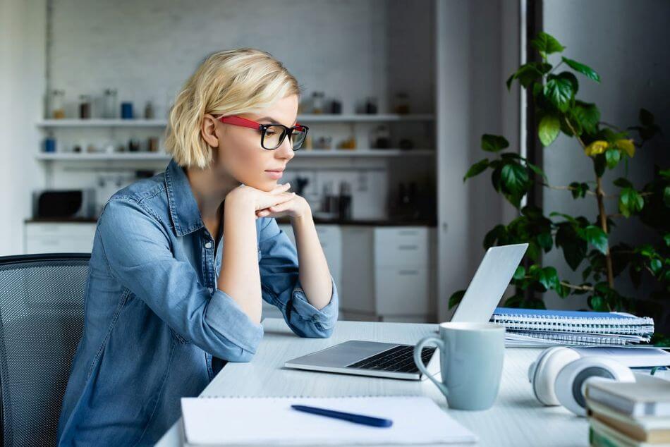 Small business owner comparing FreshBooks and Wave accounting software on laptop